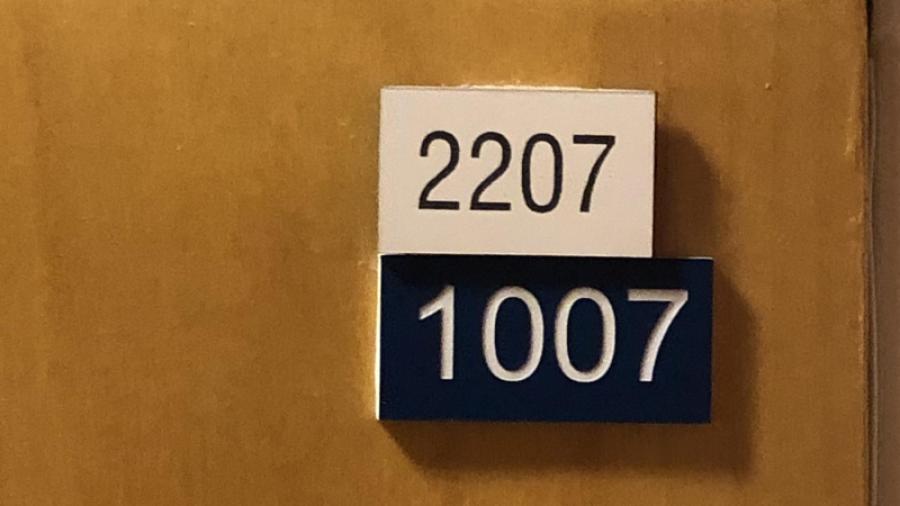 Lägenhetsdörrarnas vita skylt visar föreningens nummer och den blå visar Lantmäteriets nummer.