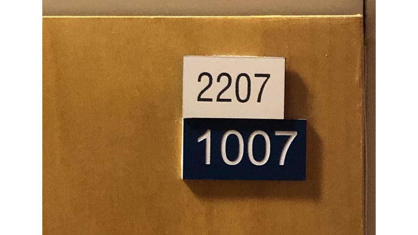 Lägenhetsdörrarnas vita skylt visar föreningens nummer och den blå visar Lantmäteriets nummer.